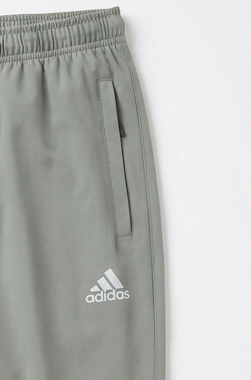 Gray Adidas athletic pants showing the side pocket and white Adidas logo on a light gray background.